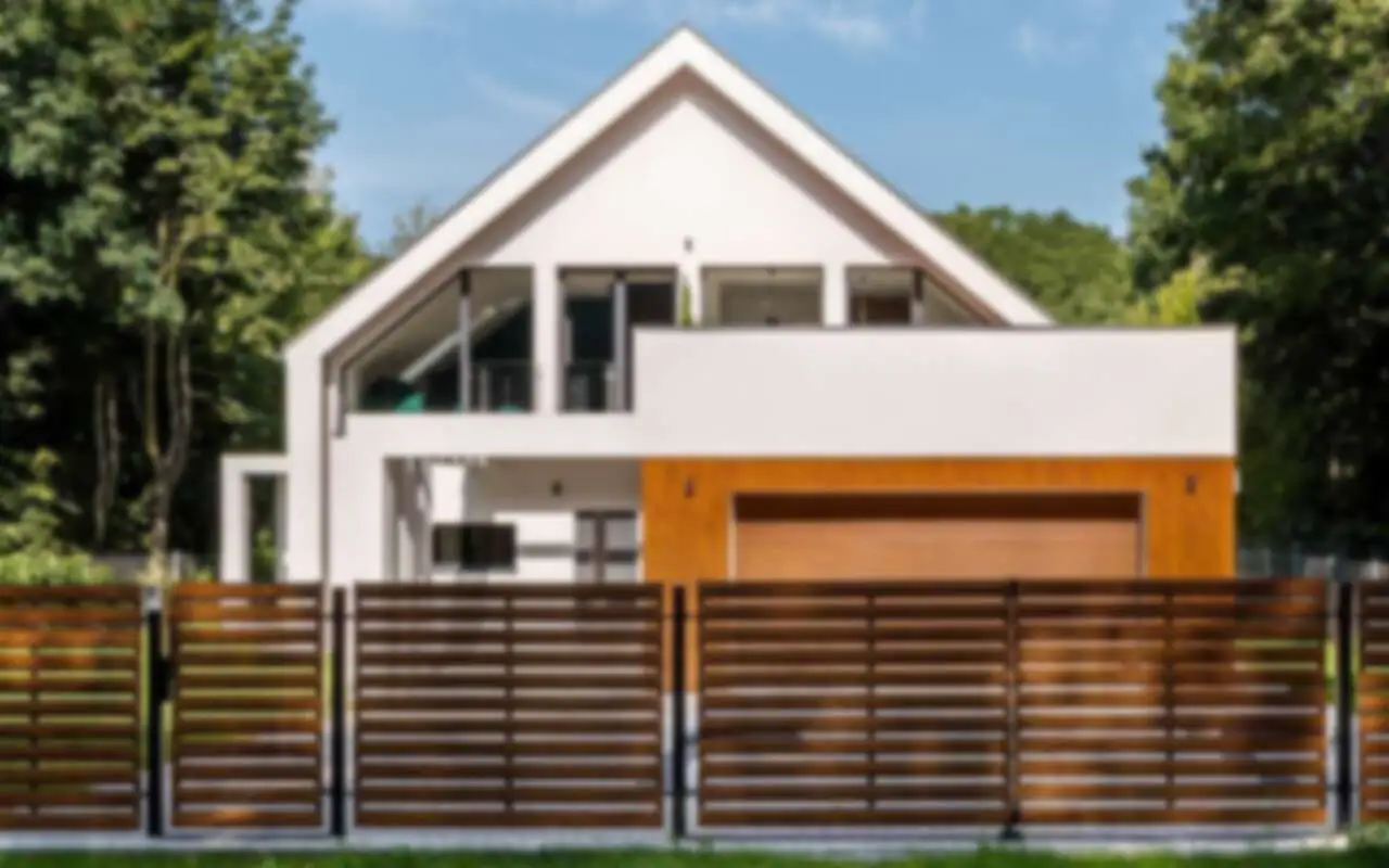 Low horizontal wood slat fence in front of a modern white house